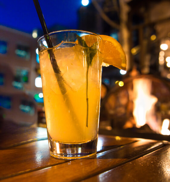 a closeup of a cocktail on a table outside at night